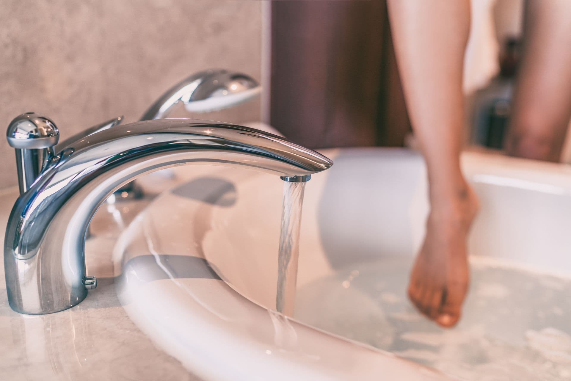 Water running bath woman dipping toes in hot bathtub relaxing time at home